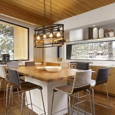 a kitchen with wooden flooring and white counter tops next to a dining room table