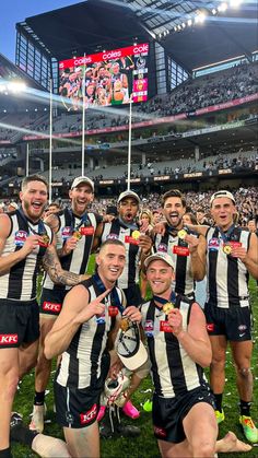 the rugby team is posing for a photo with their trophy in front of an empty stadium