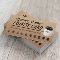 two business cards sitting on top of each other with coffee beans in the bottom one