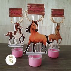 three plastic cups with horses in them on top of a wooden table next to each other