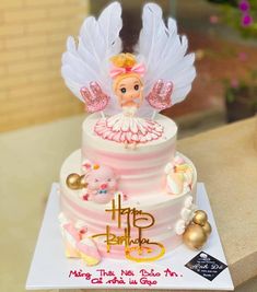 a birthday cake with an angel figurine on top