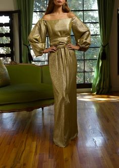 Known for using exquisite textiles from the finest European mills, Barbara Tfank’s collections are classic and timeless in French brocades, Italian silks, intricate jacquards, and more. Cut in an alluring silhouette with an off-the-shoulder neckline, this full-sleeve dress radiates in Taroni gold silk lamé. The waistline cinches with a fabric belt. Product Details Silk poly-blend. Please contact customercare@overthemoon.com if you are interested in a made-to-measure order. Care Instructions Dry-clean only. Size & Fit This item fits true to size. Shipping Details This item is made-to-order. Please allow 8-10 weeks for production and 5-7 business days for standard delivery. Return Policy This item is final sale and not available for return. Elegant Gold Evening Dress, Elegant Gold Evening Dress For Holiday, Gold Brocade Dress For Gala, Elegant Gold Holiday Dress, Fitted Brocade Dresses For An Elegant Look, Elegant Brocade Dress For Evening, Elegant Fitted Brocade Dress, Elegant Brocade Evening Dress For Formal Events, Elegant Jacquard Evening Dress For Formal Occasions