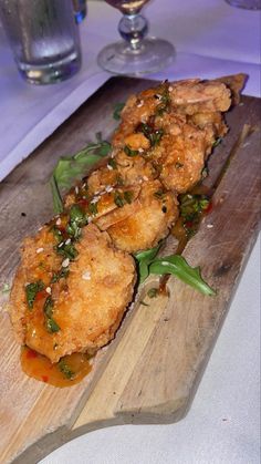 a wooden cutting board topped with fried food