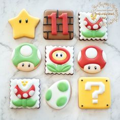 decorated cookies with different shapes and colors on a marble counter top, including one for the letter f