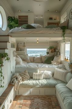 the inside of a small rv with two beds and couches on each side, in front of an ocean view