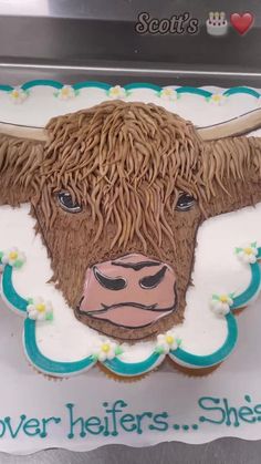 there is a cake shaped like a cow with horns on it's face and words above the head