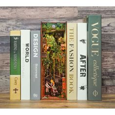 the books are stacked on top of each other in front of a wooden wall with an iron gate