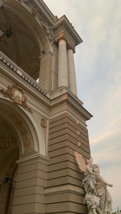 an ornate building with a clock and angel statue