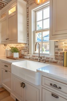 a white kitchen sink sitting under a window next to a wooden counter top and cabinets