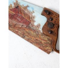 a knife with a painting on it sitting on top of a table