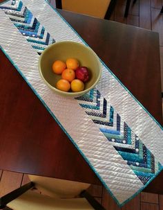 a bowl filled with fruit sitting on top of a wooden table