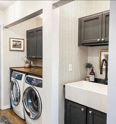 a washer and dryer are in the middle of a kitchen with dark cabinets