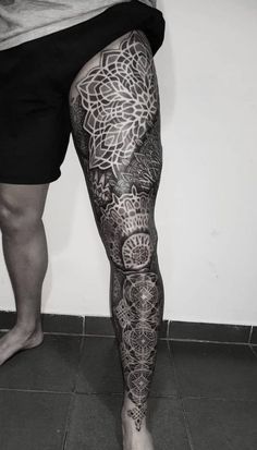 a man's leg with tattoos on it and his legs in the shape of flowers