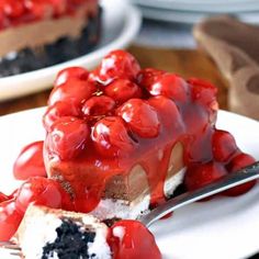 a slice of cheesecake covered in cherries on a plate