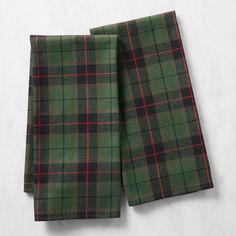 two green and black plaid napkins sitting on top of each other