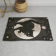 a black cat is sitting on the moon rug