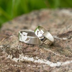 two wedding rings sitting on top of a rock