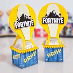 two yellow and blue paper toys with the words fortnite on them are sitting next to each other