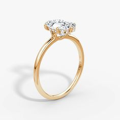 a yellow gold engagement ring with an oval center stone and three small round diamonds on the side