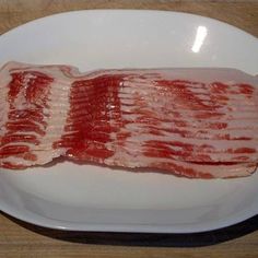 two strips of bacon on a white plate