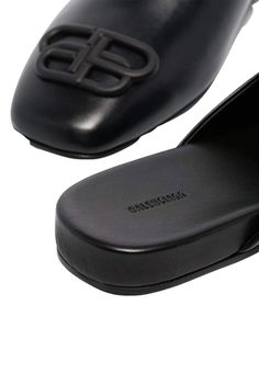 These black Balenciaga BB logo leather slipper shoes feature a square toe, slip-on design, flat sole and BB logo plaque.Calfskin leather with leather soleRubber tap heelMatte black-tone BB logo detail Composition: Leather 100%Lining Composition: Leather 100%Sole Composition: Leather 100% Fits true to sizeMade in Italy Black Calf Leather Slip-ons With Removable Insole, Leather Slip-ons With Square Toe And Rubber Sole, Luxury Leather Flat Slip-ons, Luxury Flat Slip-ons With Rubber Sole, Classic Flat Mules With Textured Sole, Designer Square Toe Mules With Branded Insole, Classic Black Mules With Textured Sole, Designer Mules With Branded Insole And Square Toe, Luxury Business Mules With Removable Insole