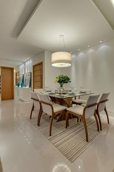 the dining room table is set with white chairs