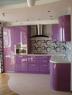 a kitchen with purple cabinets and white counter tops