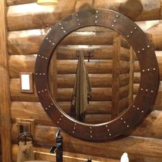 a bathroom with wooden walls and a round mirror