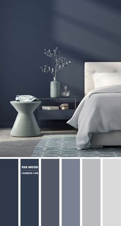 a bedroom with blue walls and white bedding in shades of gray, grey and light blue