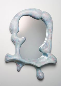 a white and blue sculpture with a mirror in the middle that is shaped to look like an octopus