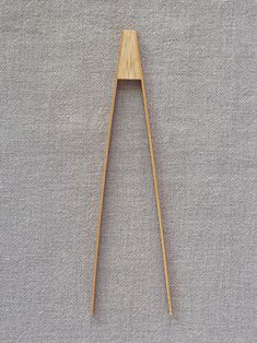 a pair of wooden chopsticks sitting on top of a gray cloth covered floor