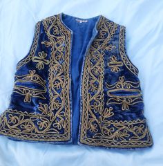 This listing is for a Vintage Blue Velvet and Gold Embroidered Vest. Size is small. In good used condition. Please see photos for detail, there are a few signs of age. Still in good shape and has lots of life left! Embroidered Vest, Velvet Vest, Flats Outfit, Gold Velvet, Gold Embroidery, Vintage Life, Vest Outfits, Blue Rose, Blue And Gold