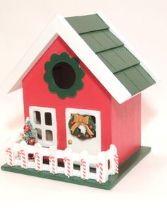 a small red house with a wreath on the door