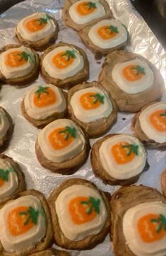 there are many cookies with cream cheese and carrots on them