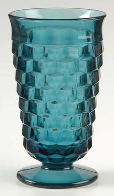 a blue glass vase sitting on top of a table