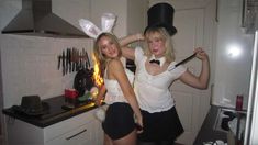 two women dressed up in bunny ears are posing for the camera and one is holding a knife