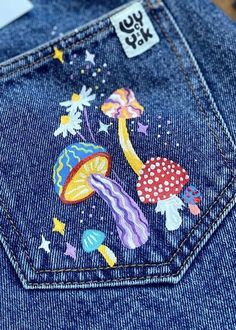 the back pocket of a pair of jeans with patches on it and an image of mushrooms