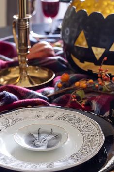 the table is set for halloween dinner with pumpkins and other holiday decorations on it