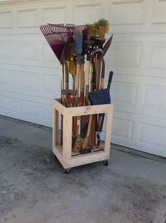 a wooden cart filled with lots of different types of gardening tools in front of a garage door