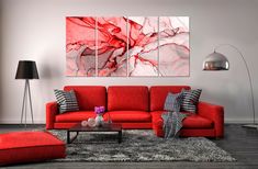 a living room with red couches and two paintings hanging on the wall above them