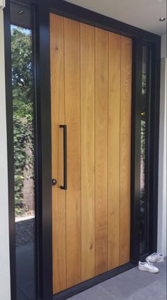 a wooden door with black frame and glass