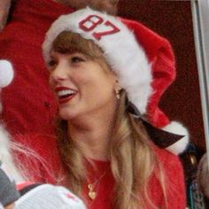 a woman wearing a santa hat while talking to someone