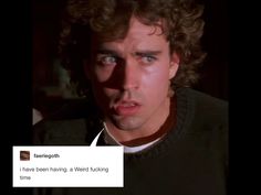 a man with curly hair is looking at the camera and has an angry look on his face