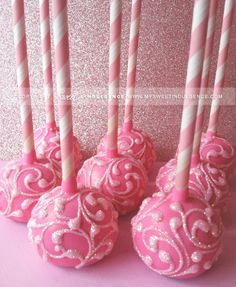 pink and white cake pops with candles in them