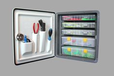 an open refrigerator with several containers and tools in it's door, on a gray background