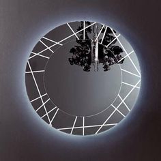 a circular mirror with trees in the center and light reflecting off it's sides