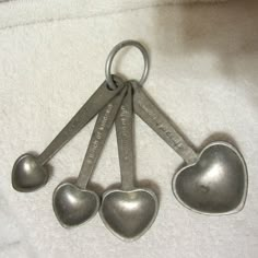 five heart shaped measuring spoons on a white towel