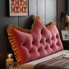 a large pink bed with ruffled pillows on it