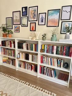 the bookshelf is full of many different types of books and pictures on the wall