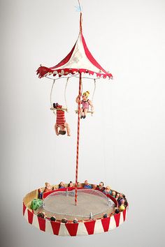 an upside down carousel with figurines hanging from it